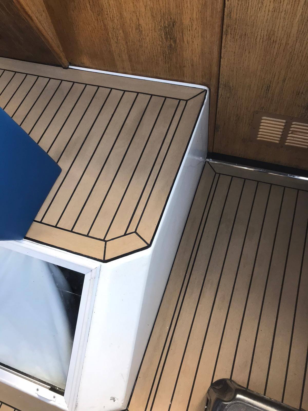 A close-up view of a Viking 22 wide beam pvc synthetic teak deck panel, showing the textured surface and caulking detail